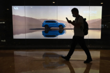 Một người đàn ông đi ngang qua bảng quảng cáo có mẫu xe mới của nhà sản xuất xe hơi điện Trung Quốc Li Auto, tại một trung tâm mua sắm ở Bắc Kinh hôm 12/08/2021. (Ảnh: Jade Gao/AFP qua Getty Images)