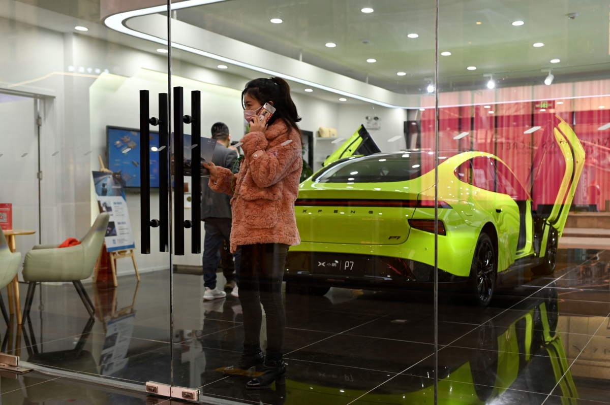 Một người phụ nữ gọi điện trong phòng trưng bày của công ty Xe hơi Tiểu Bằng (Xiaopeng Motor), ở Bắc Kinh, hôm 19/03/2021. Nhà sản xuất xe điện Trung Quốc này thường được gọi là Xpeng. (Ảnh: Wang Zhao/AFP qua Getty Images)