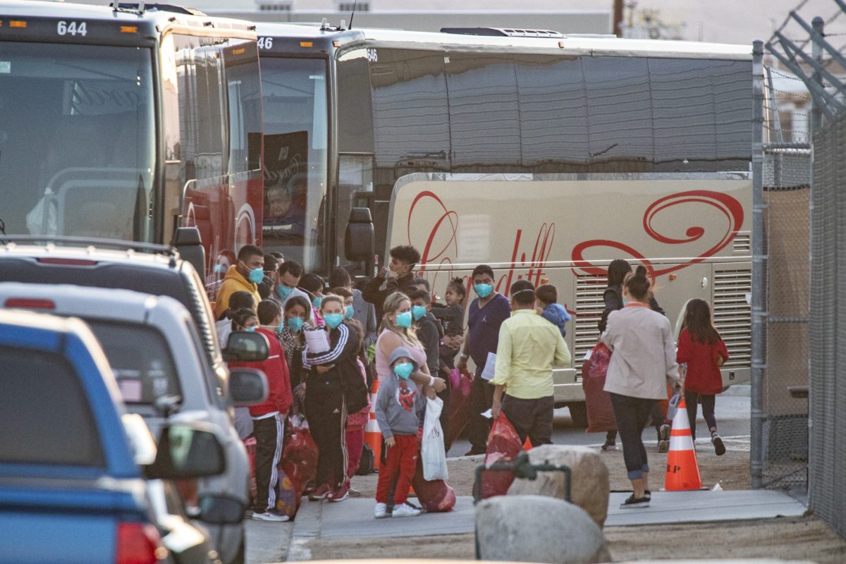 Những người nhập cư bất hợp pháp được đưa lên các xe bus thuê để chở đến một nơi trú ẩn dành cho người di cư sau khi bị các nhân viên tuần tra biên giới ở Indio, California, bắt giữ vào ngày 18/10/2021. (Ảnh: John Fredricks/The Epoch Times)
