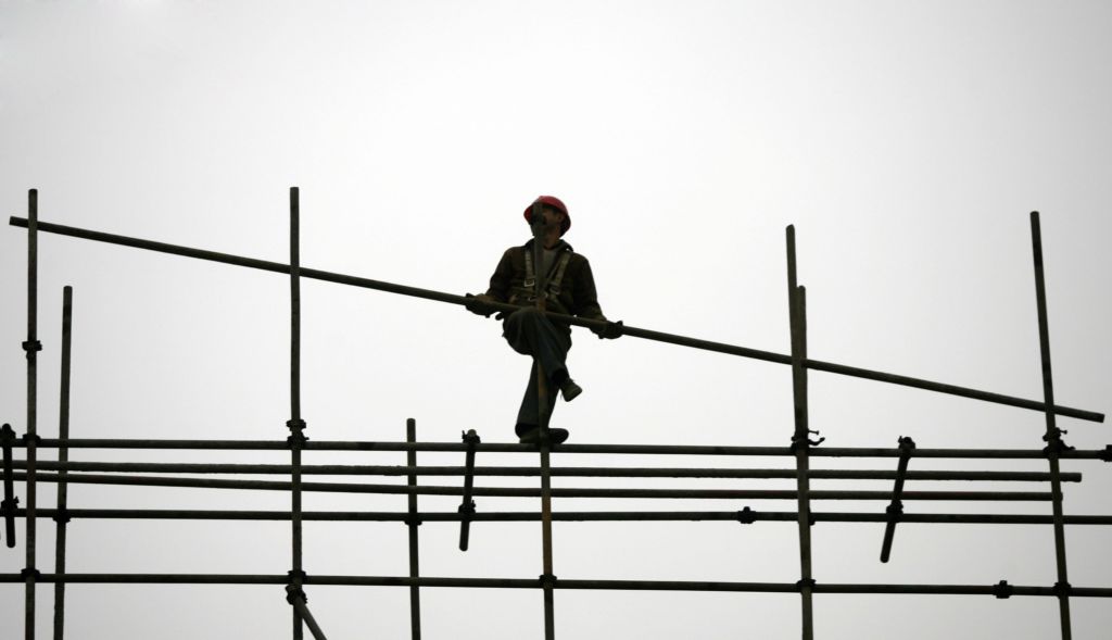 Một công nhân làm việc xa quê dựng giàn giáo tại một công trường xây dựng ở khu đô thị Trùng Khánh, Trung Quốc, vào ngày 13/01/2007. (Ảnh: Trung Quốc/Getty Images)