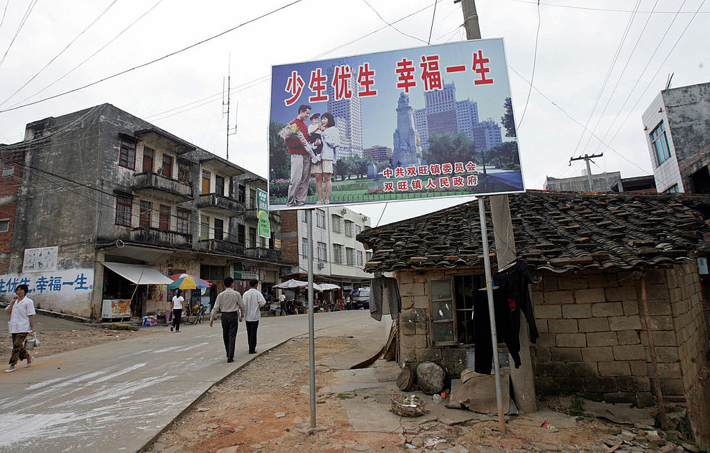 Một biển quảng cáo chính sách “một con” của Trung Quốc có nội dung: “Sinh ít con hơn, cuộc sống tốt hơn” chào đón cư dân trên đường phố chính của thị trấn Song Vượng, khu vực Quảng Tây, miền nam Trung Quốc vào ngày 25/05/2007. (Ảnh: Goh Chai Hin/AFP qua Getty Images)
