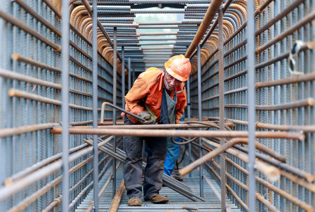 Một công nhân chuẩn bị các thanh thép tại công trường xây dựng cầu Trương Tĩnh Cao (Zhangjinggao) qua sông Dương Tử trên đảo Mã Châu ở Tĩnh Giang, tỉnh Giang Tô, miền đông của Trung Quốc hôm 14/07/2023. (Ảnh: STRINGER/AFP qua Getty Images)