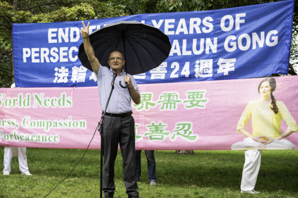 Cựu Nghị viên Đảng Bảo Thủ Wladyslaw Lizon giơ tay ra dấu chiến thắng để động viên các học viên Pháp Luân Công khi ông lên án chính quyền Trung Quốc về chiến dịch bức hại của họ, trong một cuộc tập hợp tại Công viên Nữ hoàng ở Toronto hôm 15/07/2023. (Ảnh: Evan Ning/The Epoch Times )