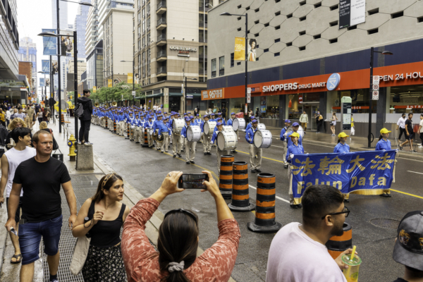 Thiên Quốc Nhạc Đoàn (Tian Guo Marching Band) tham gia một cuộc diễn hành qua trung tâm thành phố Toronto hôm 15/07/2023 để kêu gọi chính quyền Trung Quốc chấm dứt cuộc bức hại Pháp Luân Công. (Ảnh: Evan Ning/The Epoch Times)