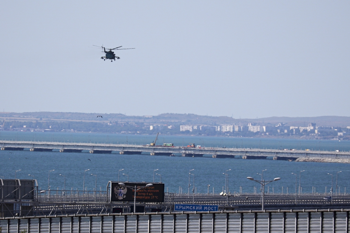 Một trực thăng quân sự của Nga bay qua các phần bị hư hỏng của một làn đường dành cho xe hơi của Cầu Crimea nối đất liền Nga với bán đảo Crimea bắc qua Eo biển Kerch không xa Kerch, Crimea, hôm 17/07/2023. (Ảnh: AP Photo)