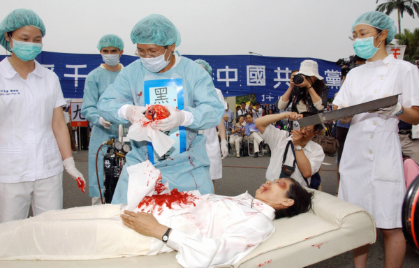 Các học viên Pháp Luân Công trong buổi tái hiện hoạt động thu hoạch nội tạng từ các học viên Pháp Luân Công của Đảng Cộng sản Trung Quốc, trong một cuộc mít tinh ở Đài Bắc, Đài Loan, vào ngày 23/04/2006. (Ảnh: Patrick Lin/AFP qua Getty Images)