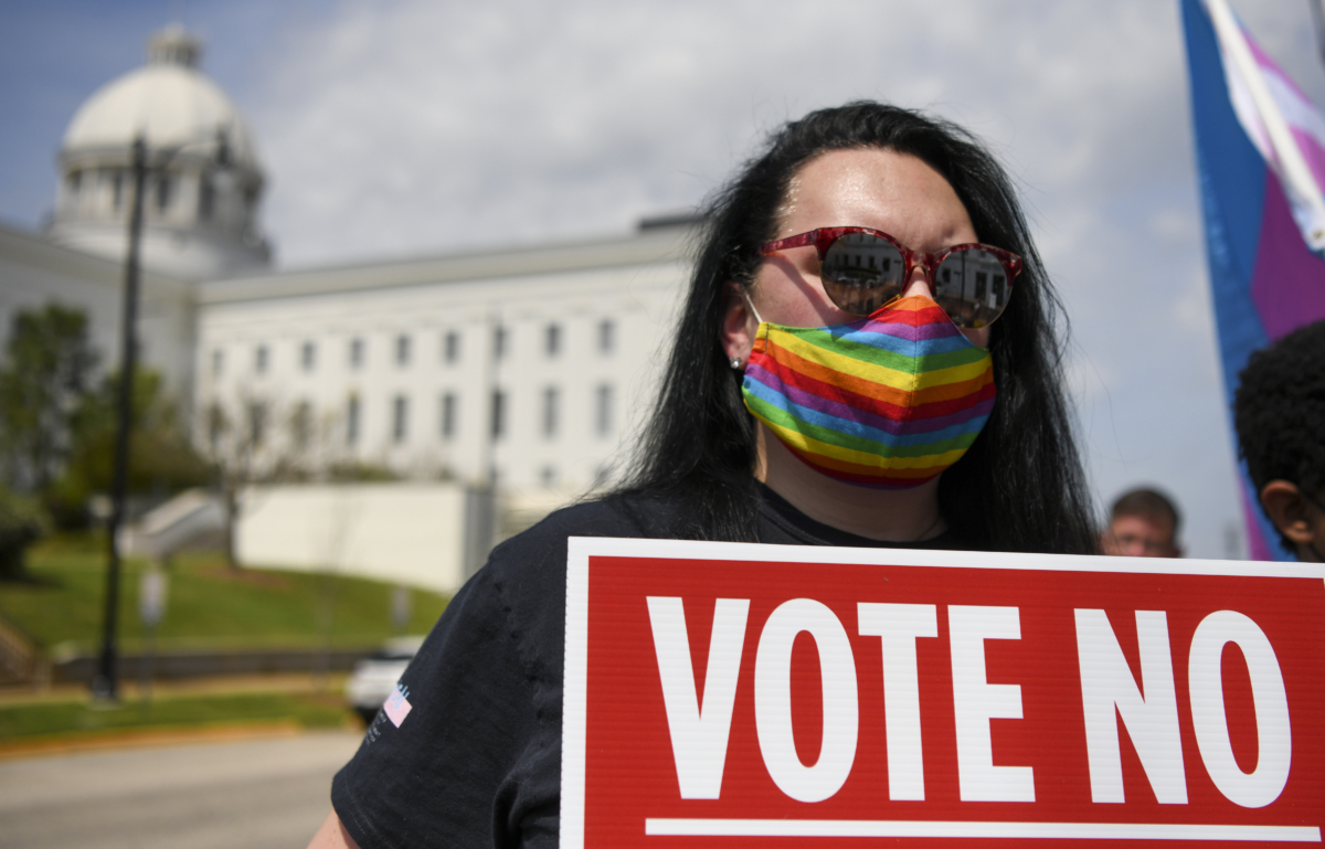 Một người biểu tình giơ một tấm biển trong cuộc tập hợp tại Tòa nhà Chính phủ tiểu bang Alabama để thu hút sự chú ý đến luật về vấn đề chuyển giới được đưa ra ở Alabama ở Montgomery, Alabama, vào ngày 30/03/2021. (Ảnh: Julie Bennett/Getty Images)