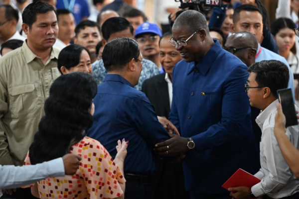 Thủ tướng Campuchia Hun Sen (ở giữa bên trái) bắt tay với Thủ tướng Guinea-Bissau Nuno Gomes Nabiam sau khi ông Hun Sen bỏ phiếu tại một điểm bỏ phiếu ở tỉnh Kandal trong cuộc tổng tuyển cử hôm 23/07/2023. (Ảnh: Tang Chhin Sothy/AFP qua Getty Images)