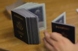 Một nhân viên giải quyết hộ chiếu dùng một chồng hộ chiếu trống để in hộ chiếu mới tại Cơ quan Hộ chiếu Miami ở Miami, Florida, ngày 22/06/2007. (Ảnh: Joe Raedle/Getty Images)
