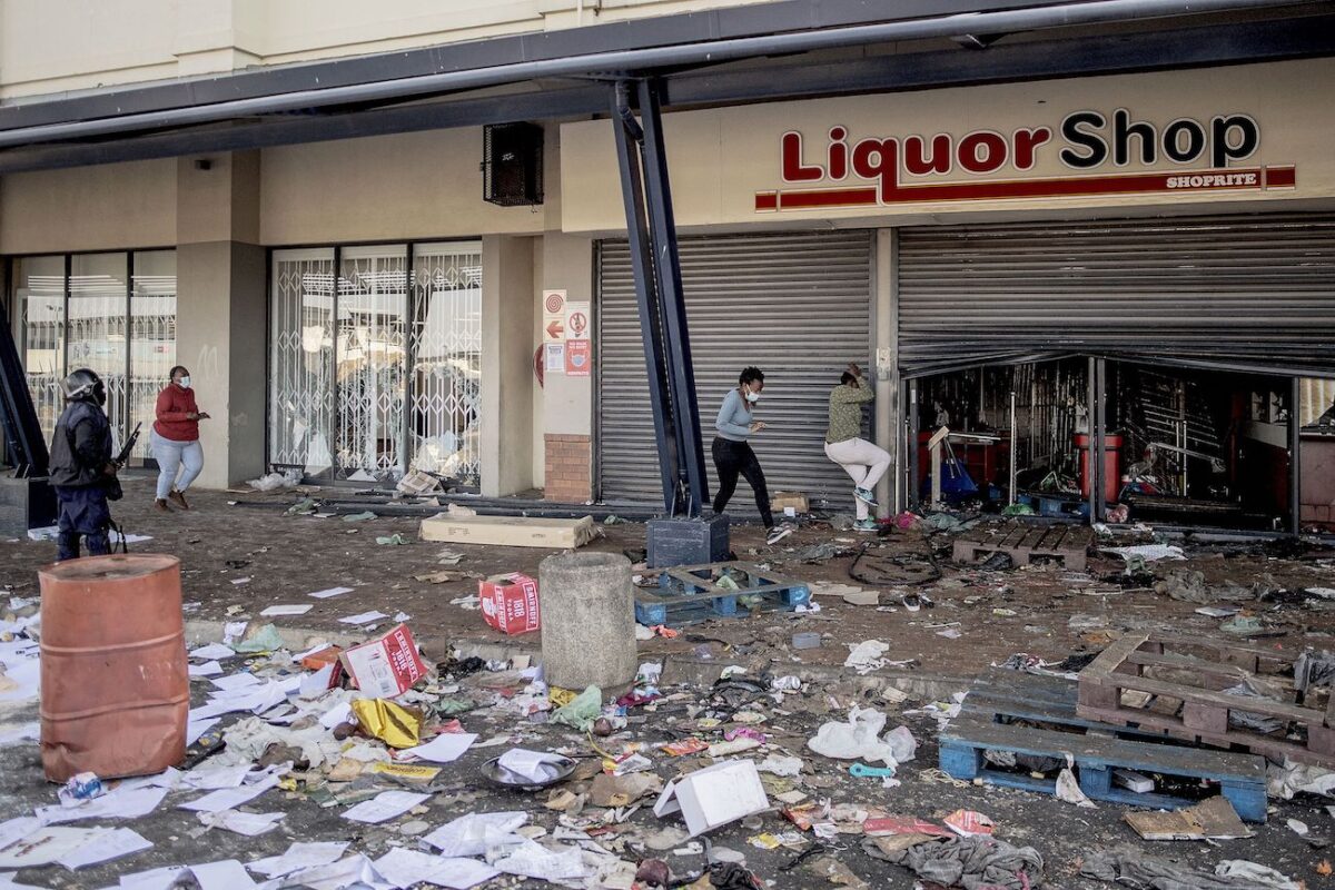 Một sĩ quan Sở cảnh sát Nam Phi cố gắng giải tán những kẻ bạo loạn cướp phá một cửa hàng rượu tại Trung tâm thương mại Jabulani ở quận Soweto của Johannesburg vào ngày 12/07/2021. (Ảnh: Luca Sola/AFP qua Getty Images)