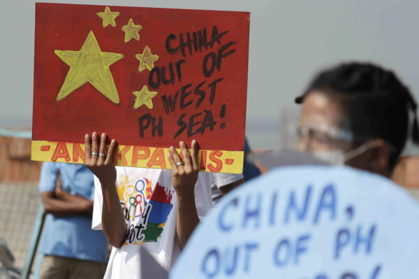 Một người biểu tình giơ tấm biển phản đối một luật của Hải Cảnh Trung Quốc mới được thông qua trong một cuộc biểu tình ở Manila, Philippines, vào ngày 24/02/2021. Các quan chức cho biết, hôm thứ Hai, ngày 14/03/2022, chính phủ Philippines đã triệu tập đại sứ Trung Quốc để phản đối điều mà họ nói là “sự xâm nhập bất hợp pháp” của một tàu hải quân Trung Quốc vào vùng lãnh hải nước này trong ba ngày và yêu cầu Trung Quốc ra lệnh cho các tàu của họ phải tôn trọng lãnh thổ nước này và tuân theo luật pháp quốc tế. (Ảnh: AP Photo/Aaron Favila, Tư liệu)