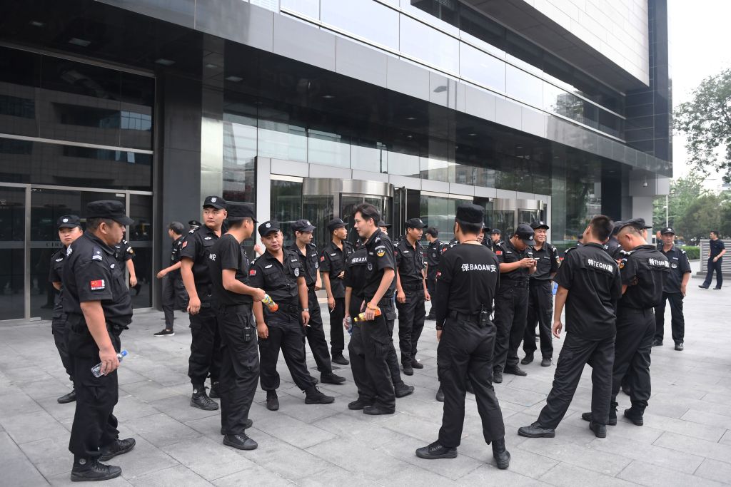 Nhân viên an ninh đứng trước Ủy ban Điều tiết Ngân hàng Trung Quốc tại Bắc Kinh, Trung Quốc, vào ngày 06/08/2018, sau khi công an Trung Quốc mạnh tay dập tắt một cuộc biểu tình đã được lên kế hoạch từ trước để phản đối những tổn thất do các nền tảng cho vay ngang hàng (P2P) gây ra. (Ảnh: Greg Baker/AFP qua Getty Images)