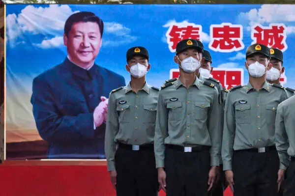 Các binh sĩ của Tiểu đoàn Cảnh vệ thuộc Quân Giải phóng Nhân dân đứng nghiêm ở phía trước bức ảnh của lãnh đạo Trung Quốc Tập Cận Bình tại doanh trại của họ bên ngoài Tử Cấm Thành, gần Quảng trường Thiên An Môn, ở Bắc Kinh vào ngày 20/05/2020. (Ảnh: Kevin Frayer/Getty Images)