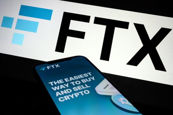 Logo FTX và quảng cáo ứng dụng dành cho thiết bị di động được hiển thị trên màn hình ở London vào ngày 10/11/2022. (Ảnh: Leon Neal/Getty Images)