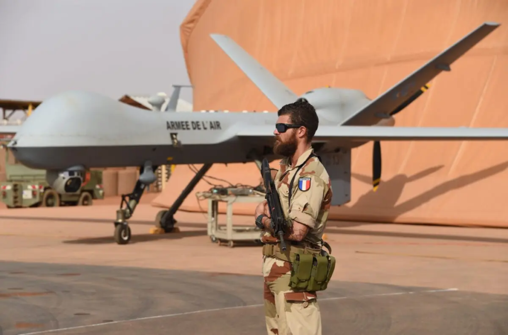 Một người lính Pháp tham gia Chiến dịch Barkhane chống quân nổi dậy trong khu vực đứng bảo vệ bên cạnh một phi cơ không người lái Reaper tại căn cứ không quân của quân đội Pháp ở Niamey, Niger, vào ngày 14/03/2016. (Ảnh: Pascal Guyot/AFP qua Getty Images)