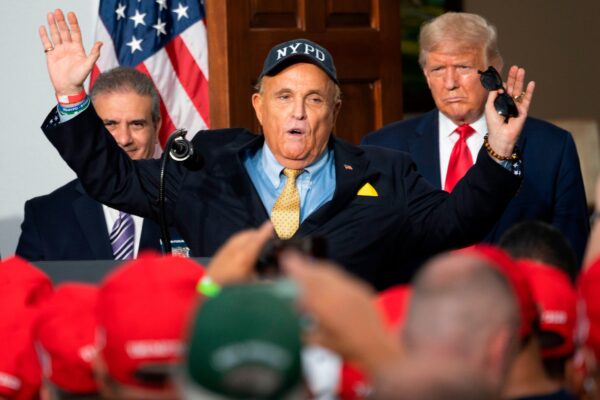 Tổng thống Hoa Kỳ Donald Trump (phải) lắng nghe khi luật sư riêng Rudy Giuliani nói chuyện với Hiệp hội Nhân từ của Cảnh sát Thành phố New York tại Câu lạc bộ Golf Quốc gia Trump ở Bedminster, New Jersey, vào ngày 14/08/2020. (Ảnh: Jim Watson/AFP qua Getty Images)