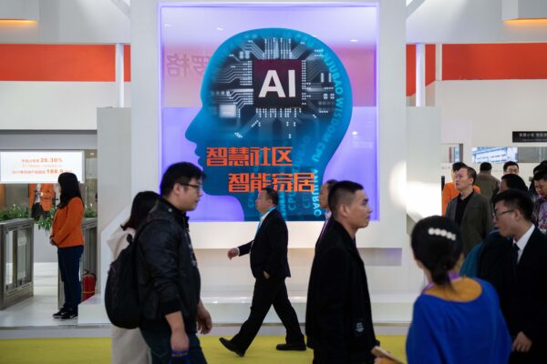 Du khách đi ngang qua gian hàng có camera an ninh AI sử dụng công nghệ nhận dạng khuôn mặt tại Triển lãm Quốc tế về An toàn và An ninh Công cộng lần thứ 14 của Trung Quốc tại Trung tâm Triển lãm Quốc tế Trung Quốc ở Bắc Kinh vào ngày 24/10/2018. (Ảnh: Nicolas Asfouri/AFP qua Getty Images)