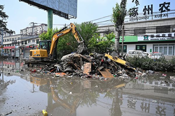 Hôm 09/08/2023, thành phố Trác Châu, tỉnh Hà Bắc, Trung Quốc, trở nên hoang tàn, cơ sở hạ tầng bị hư hại. Một công nhân dọn rác trên đường phố. (Ảnh: Jade Gao/AFP)