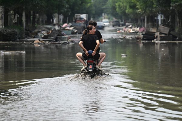 Hôm 09/08/2023, người dân địa phương đi xe máy dọc theo những con đường ngập nước ở thành phố Trác Châu, tỉnh Hà Bắc, Trung Quốc. (Ảnh: Jade Gao/AFP)