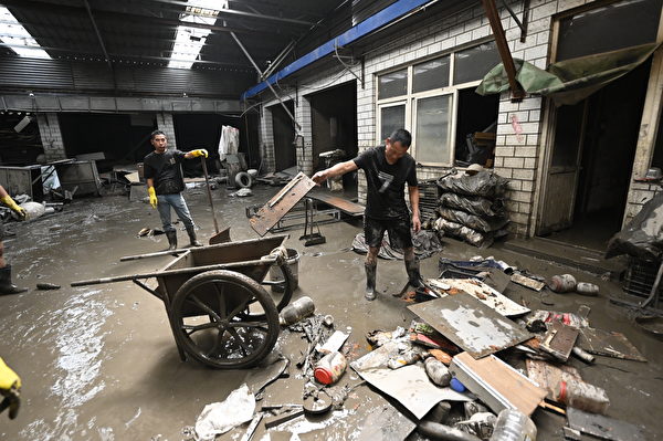 Hôm 09/08/2023, công nhân dọn dẹp bùn đất và mảnh vụn tại một nhà kho ở thành phố Trác Châu, tỉnh Hà Bắc, Trung Quốc. (Ảnh: Jade Gao/AFP)