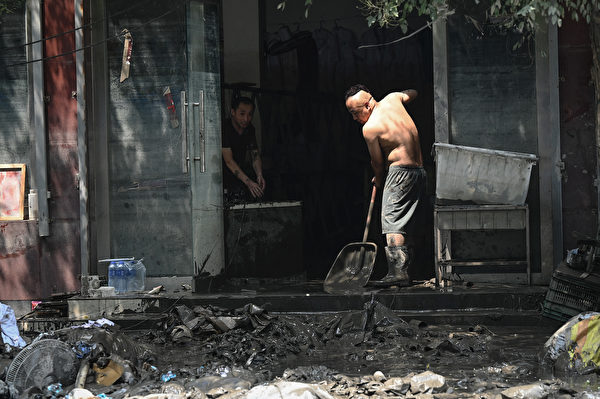 Hôm 09/08/2023, thành phố Trác Châu, tỉnh Hà Bắc, Trung Quốc, trở nên hoang tàn, cơ sở hạ tầng bị hư hại. Một người dân dọn dẹp nhà cửa của mình. (Ảnh: Jade Gao/AFP)