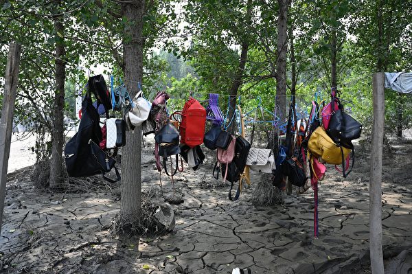 Hôm 09/08/2023, người dân phơi túi xách và ba lô trên con đường lầy lội sau trận lũ ở thành phố Trác Châu, tỉnh Hà Bắc, Trung Quốc. (Ảnh: Jade Gao/AFP)