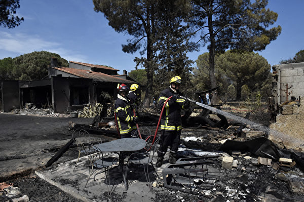 Lính cứu hỏa phun nước vào đống đổ nát của những ngôi nhà sau khi cháy rừng hoành hành ở Saint-André, Pháp, hôm 15/08/2023. (Ảnh: Raymond Roig/AFP)