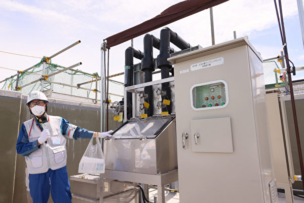 Hôm 27/08/2023, một quan chức trưng bày thiết bị lấy mẫu nước để phân tích nồng độ tritium phóng xạ trước khi xả nước, thuộc cơ sở xả nước đã qua xử lý tại nhà máy điện hạt nhân Fukushima Daiichi của Công ty Tập đoàn Điện lực Tokyo (TEPCO). (Ảnh: HAPAN POOL/JIJI PRESS/AFP qua Getty Images)