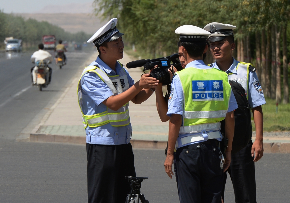 Công an Trung Quốc bắt giữ một ký giả tại một trạm kiểm soát trên đường đến thị trấn Lukqun của người Duy Ngô Nhĩ bị ảnh hưởng bởi bạo loạn, ở tỉnh Tân Cương, Trung Quốc, vào ngày 28/06/2013. (Ảnh: Mark Ralston/AFP qua Getty Images)