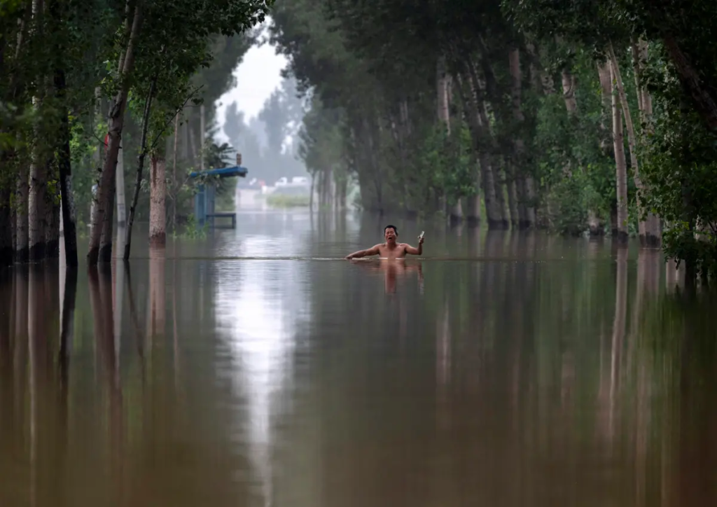 Một người dân đi bộ trong nước lũ ngập đến ngực gần Trác Châu, tỉnh Hà Bắc, phía nam Bắc Kinh, Trung Quốc, hôm 03/08/2023. (Ảnh: Kevin Frayer/Getty Images)