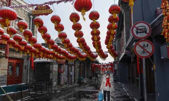 Một phụ nữ Trung Quốc đeo khẩu trang bảo hộ khi đi bộ trên một con phố thương mại vắng vẻ và gần như không cửa hàng nào mở cửa ở Bắc Kinh, Trung Quốc, vào ngày 07/02/2020. (Ảnh: Kevin Frayer/Getty Images)