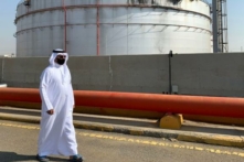 Một người đàn ông đeo khẩu trang do đại dịch virus corona COVID-19 đi ngang qua một bình chứa bị hư tại cơ sở dầu mỏ của Saudi Aramco ở thành phố Jeddah bên Hồng Hải của Saudi Arabia, hôm 24/11/2020. (Ảnh: Fayez Nureldine/AFP qua Getty Images)