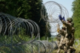 Các binh sĩ quân đội Lithuania đặt dây thép gai tại biên giới với Belarus ở Druskininkai, Lithuania, vào ngày 09/07/2021. (Ảnh: Janis Laizans/Reuters)