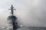 Tàu hộ tống Kurama của Lực lượng Phòng vệ Hàng hải Nhật Bản (MSDF) xuyên qua làn khói trong một cuộc thao diễn hạm đội ngoài khơi Vịnh Sagami, tỉnh Kanagawa, vào ngày 18/10/2015. Ba mươi sáu tàu MSDF và tàu hải quân từ Úc, Ấn Độ, Pháp, Nam Hàn, và Hoa Kỳ tham gia cuộc thao diễn hạm đội này. (Ảnh: Toru Yamanaka/AFP qua Getty Images)