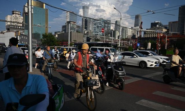 Người dân chờ để băng qua đường ở Bắc Kinh hôm 20/06/2023. (Ảnh: Greg Baker/AFP qua Getty Images)