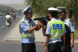 Công an Trung Quốc bắt giữ một ký giả tại một trạm kiểm soát trên một con đường dẫn vào thị trấn Lukqun của người Duy Ngô Nhĩ bị ảnh hưởng bởi bạo loạn, thuộc tỉnh Tân Cương, vào ngày 28/06/2013. (Ảnh: Mark Ralston/AFP qua Getty Images)