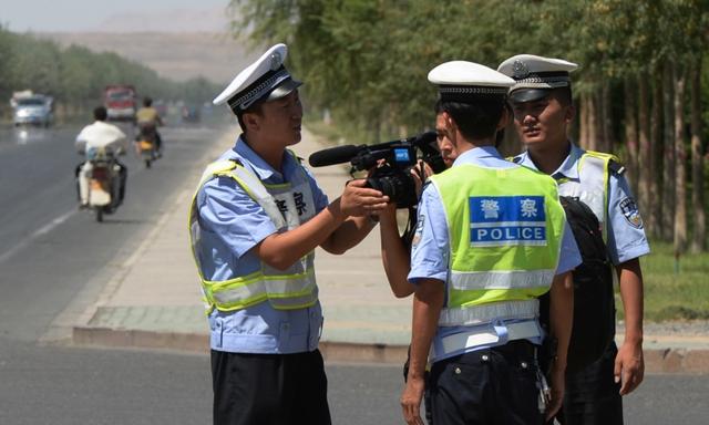 Công an Trung Quốc bắt giữ một ký giả tại một trạm kiểm soát trên một con đường dẫn vào thị trấn Lukqun của người Duy Ngô Nhĩ bị ảnh hưởng bởi bạo loạn, thuộc tỉnh Tân Cương, vào ngày 28/06/2013. (Ảnh: Mark Ralston/AFP qua Getty Images)