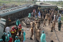 Lực lượng kiểm lâm bán quân sự và các tình nguyện viên kiểm tra các toa xe lửa tại địa điểm xảy ra tai nạn sau vụ trật đường ray của một đoàn xe lửa chở khách ở Nawabshah, Pakistan, hôm 06/08/2023. (Ảnh: Husnain Ali/AFP qua Getty Images)