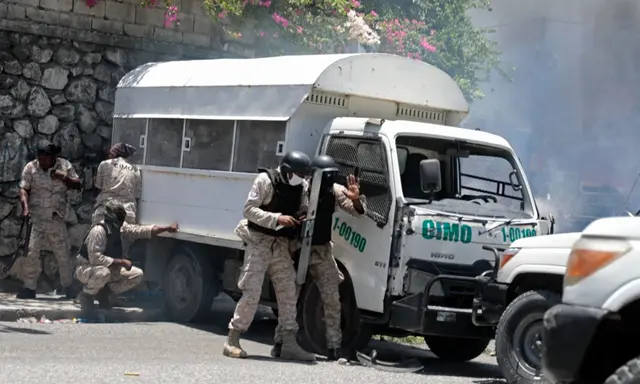 Cảnh sát ẩn nấp để tránh đá do người biểu tình ném ở Port-au-Prince, Haiti, hôm 07/08/2023. (Ảnh: Odelyn Joseph/AP Photo)