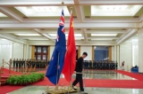 Một nhân viên thu dọn quốc kỳ khi kết thúc cuộc gặp giữa Thủ tướng Trung Quốc Lý Khắc Cường và Thủ tướng đương thời Jacinda Ardern của New Zealand tại Đại lễ đường Nhân dân ở Bắc Kinh vào ngày 01/04/2019. (Ảnh: Andrea Verdelli/Getty Images)