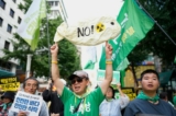 Người dân giơ cao các tấm biểu ngữ và bích chương để phản đối kế hoạch của Nhật Bản xả nước phóng xạ đã qua xử lý từ nhà máy điện hạt nhân Fukushima bị hư hỏng, trong một cuộc tuần hành dọc theo một con đường ở Seoul, Nam Hàn, hôm 12/08/2023. (Ảnh: AP Photo/Lee Jin-man)