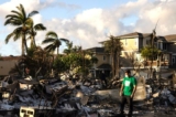 Một tình nguyện viên đánh giá thiệt hại của một khu chung cư bị cháy thành than sau vụ cháy rừng ở Lahaina, phía tây Maui, Hawaii, hôm 12/08/2023. (Ảnh: Yuki Iwamura/AFP qua Getty Images)