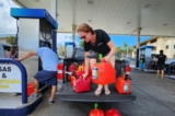 Bà Sarah Turner ở Tây Maui đổ đầy xăng vào các thùng chứa để cung cấp năng lượng cho máy phát điện khẩn cấp của mình và giúp đỡ những người hàng xóm cần nhiên liệu, hôm 16/08/2023. (Ảnh: Allan Stein/The Epoch Times)