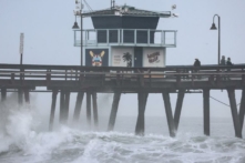 Người dân đứng trên một bến tàu nhìn ra Thái Bình Dương khi cơn bão nhiệt đới Hilary tiến đến quận San Diego ở Imperial Beach, California, hôm 20/08/2023. (Ảnh: Mario Tama/Getty Images)