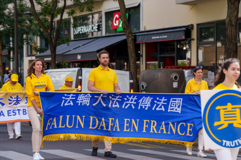 Các học viên cầm biểu ngữ Pháp Luân Đại Pháp tại Pháp trong buổi diễn hành ở thành phố Paris, Pháp, hôm 26/08/2023. (Ảnh: Alexander Gereg)