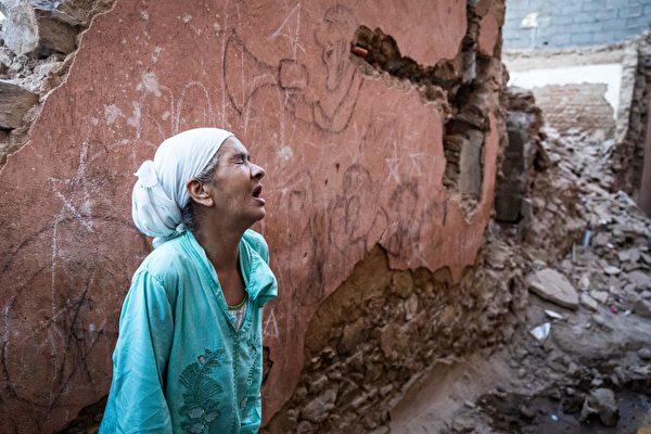 Hôm 09/09, tại thành phố Marrakech, một người phụ nữ đau khổ đứng trước ngôi nhà hư hại do động đất. Tối ngày 08/09, một trận động đất mạnh xảy ra ở Morocco, khiến hơn 2,000 người thiệt mạng, người dân hoảng sợ bỏ chạy khỏi nhà vào lúc nửa đêm. (Ảnh: Fadel Senna/AFP qua Getty Images)