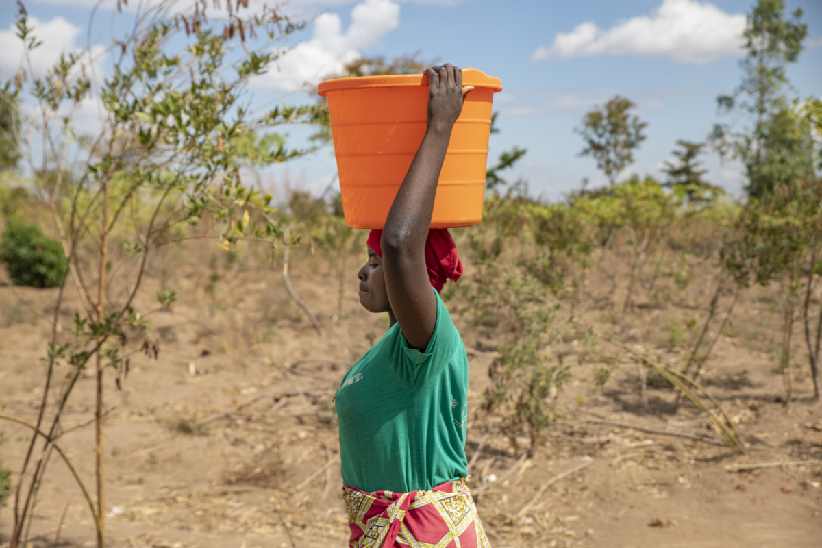Một người phụ nữ mang nước về nhà ở Làng Lupapa, Malawi, vào ngày 06/07/2021. (Ảnh: John Fredricks/The Epoch Times)