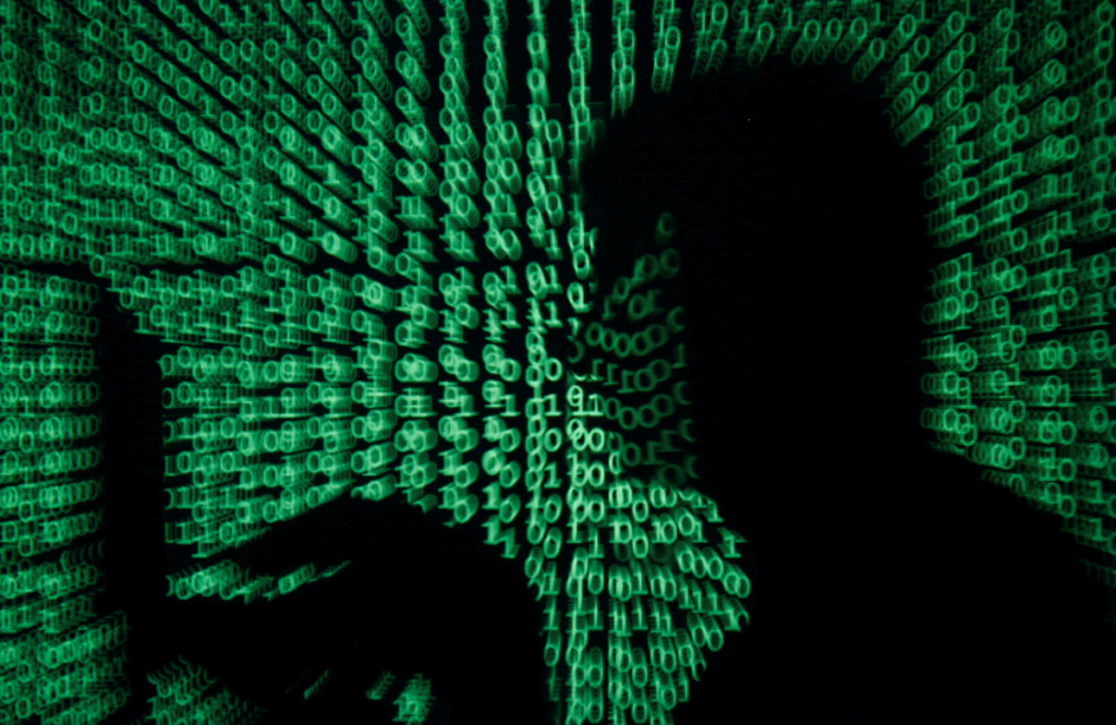Mã mạng (cyber code) chiếu vào một người đàn ông cầm máy điện toán xách tay trong bức ảnh minh họa được chụp vào ngày 13/05/2017 này. (Ảnh: Kacper Pempel/Reuters)