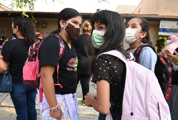 Học sinh và phụ huynh đeo khẩu trang đến trong ngày đầu tiên của năm học tại Trường Tiểu học Grant ở Los Angeles, California, vào ngày 16/08/2021. (Ảnh: Robyn Beck/AFP qua Getty Images)