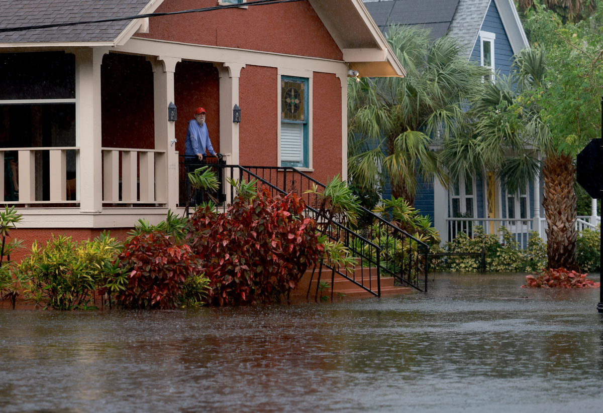 Ông Steve Odom đứng trước hiên nhà của mình ở Tarpon Springs, Florida, hôm 30/08/2023, nơi vẫn bị bao quanh bởi nước lũ do bão Idalia đi qua ngoài khơi vào đêm hôm trước. (Ảnh: Joe Raedle/Getty Images)